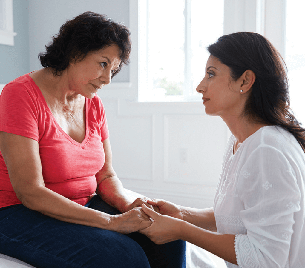 Adult daughter consoles senior mother.