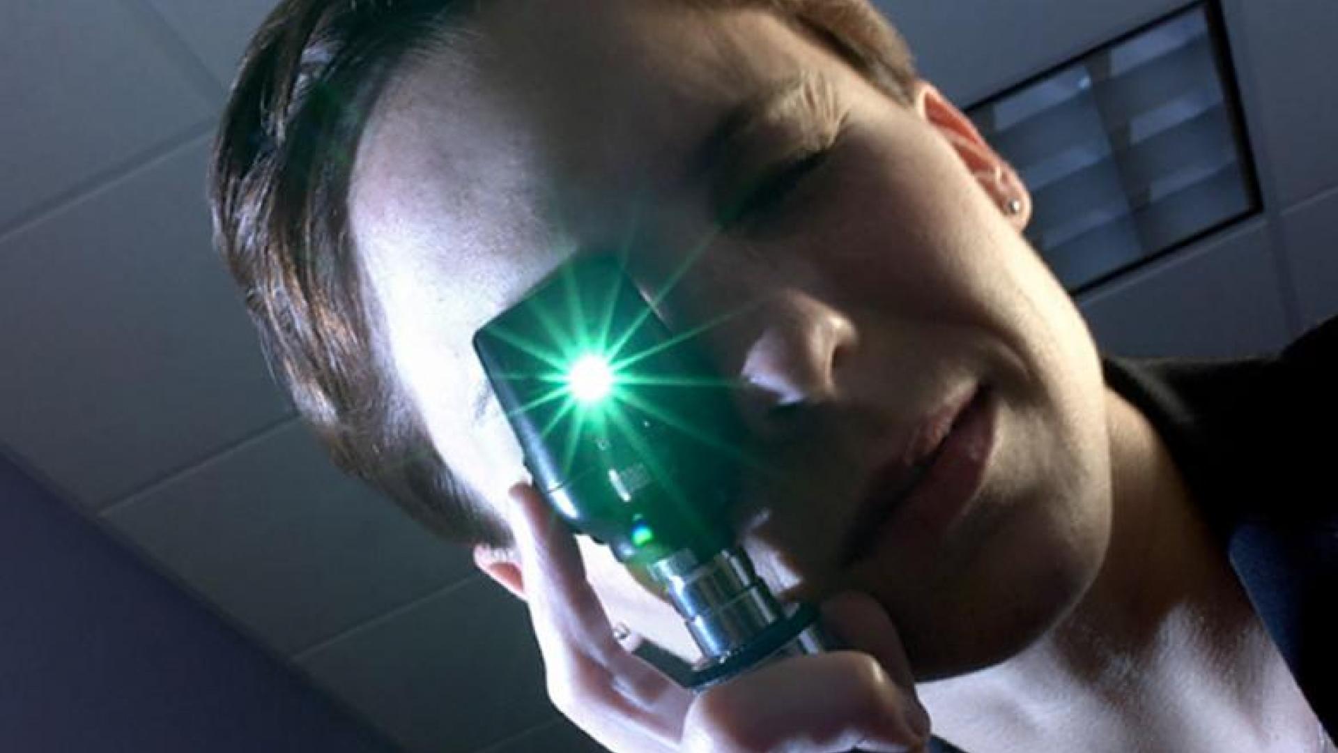 An eye doctor looking through an ophthalmoscope.