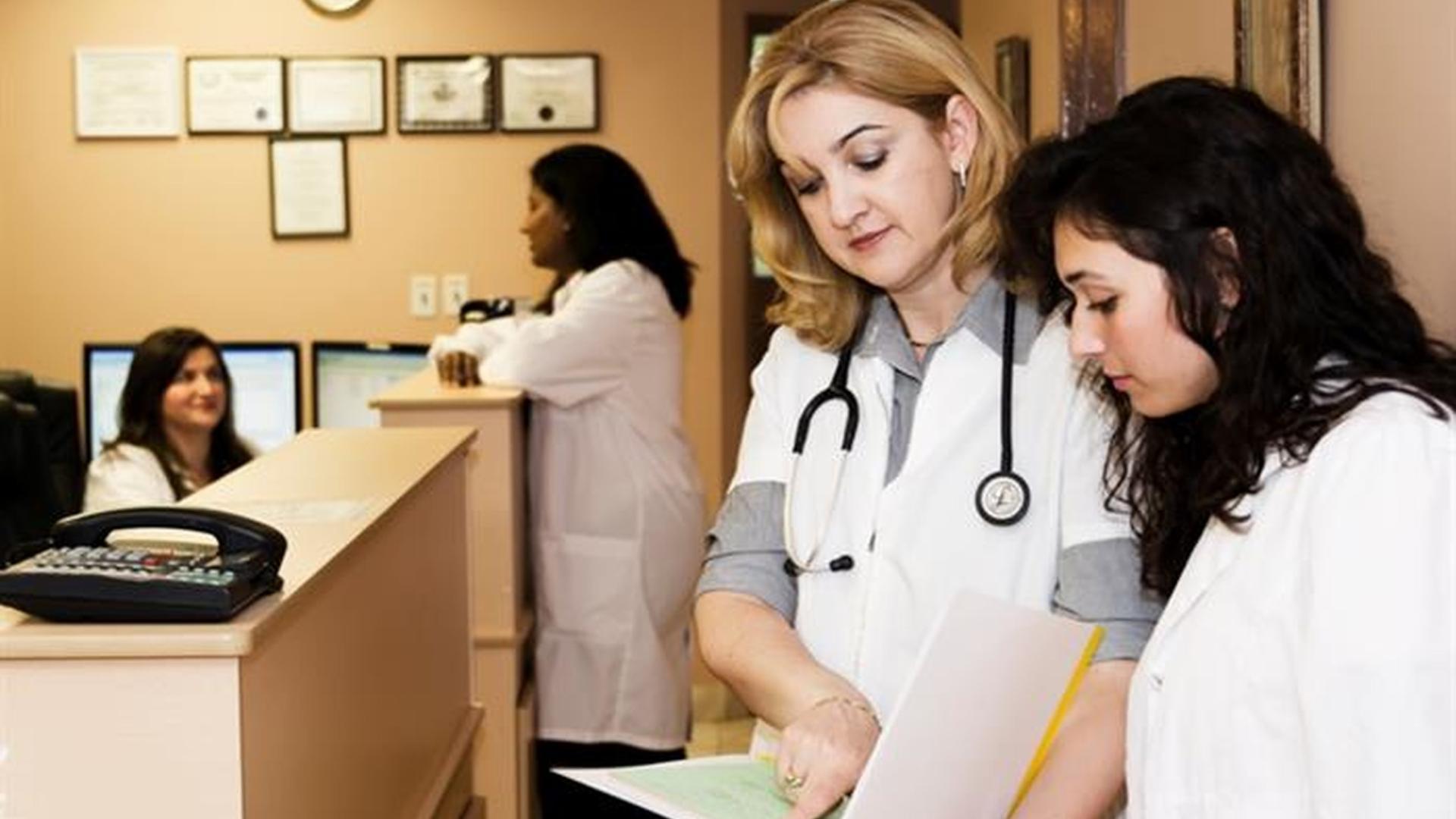 A doctor reviewing a patient's chart with a nurse.