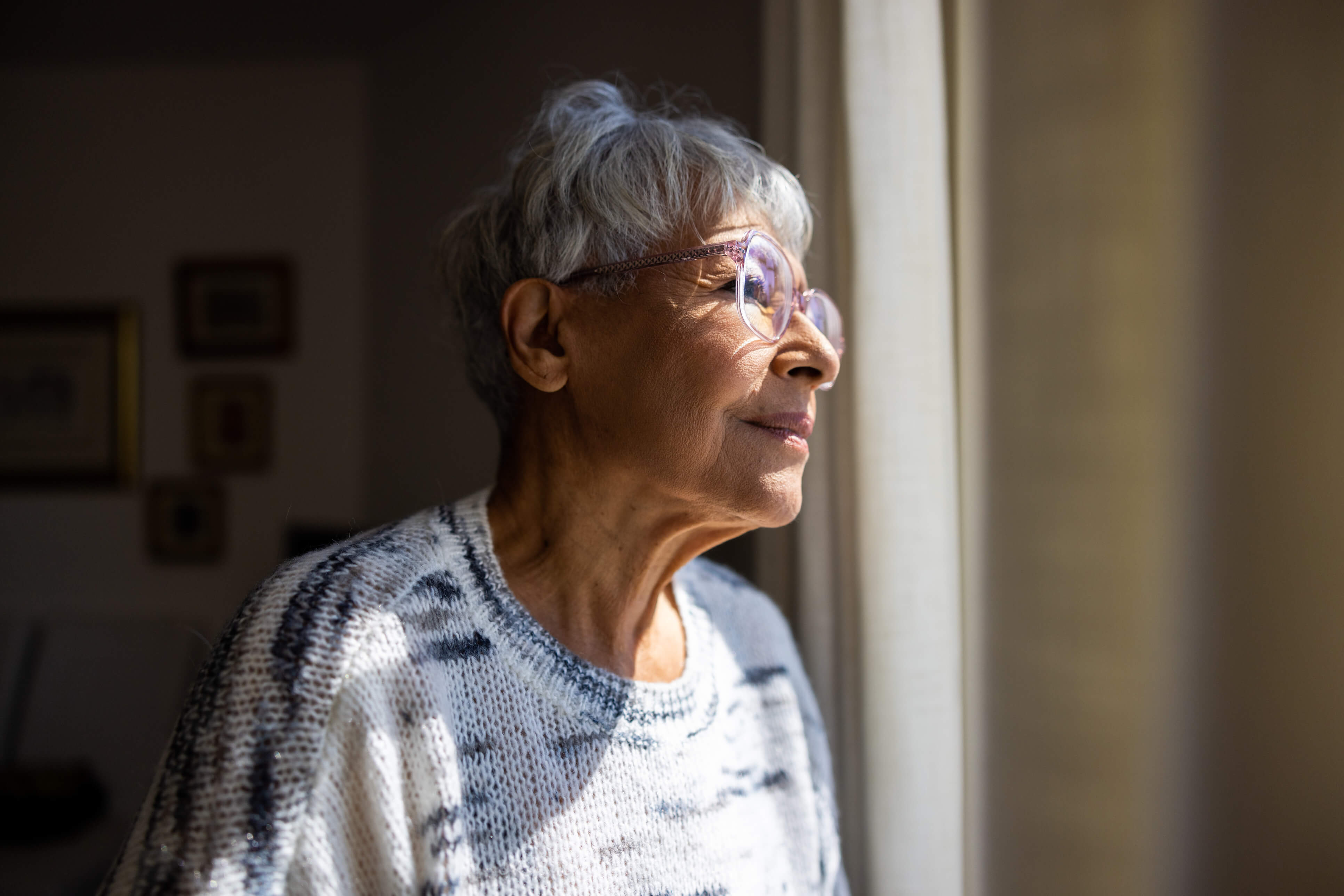 Senior woman looking out window.