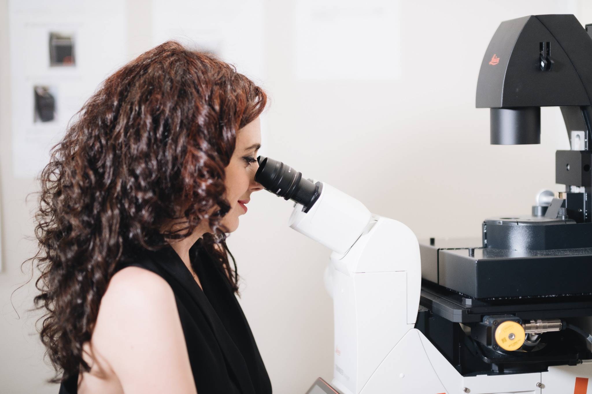 Scientist using a microscope in a lab.