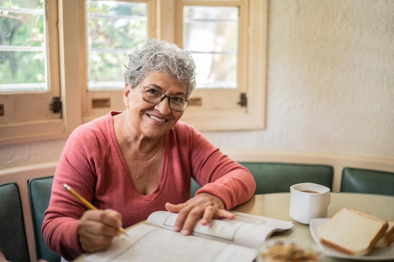 Portrait of a senior woman playing with crosswords at home