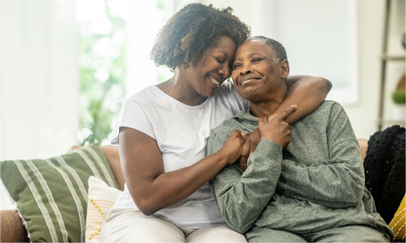 Daughter and senior mother embracing each other at home.