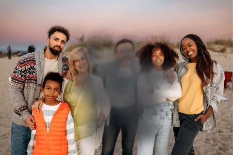 The same family on the beach at sunset, with the same people visible. In this image, the faces of the older woman and the man in the middle are blurred.