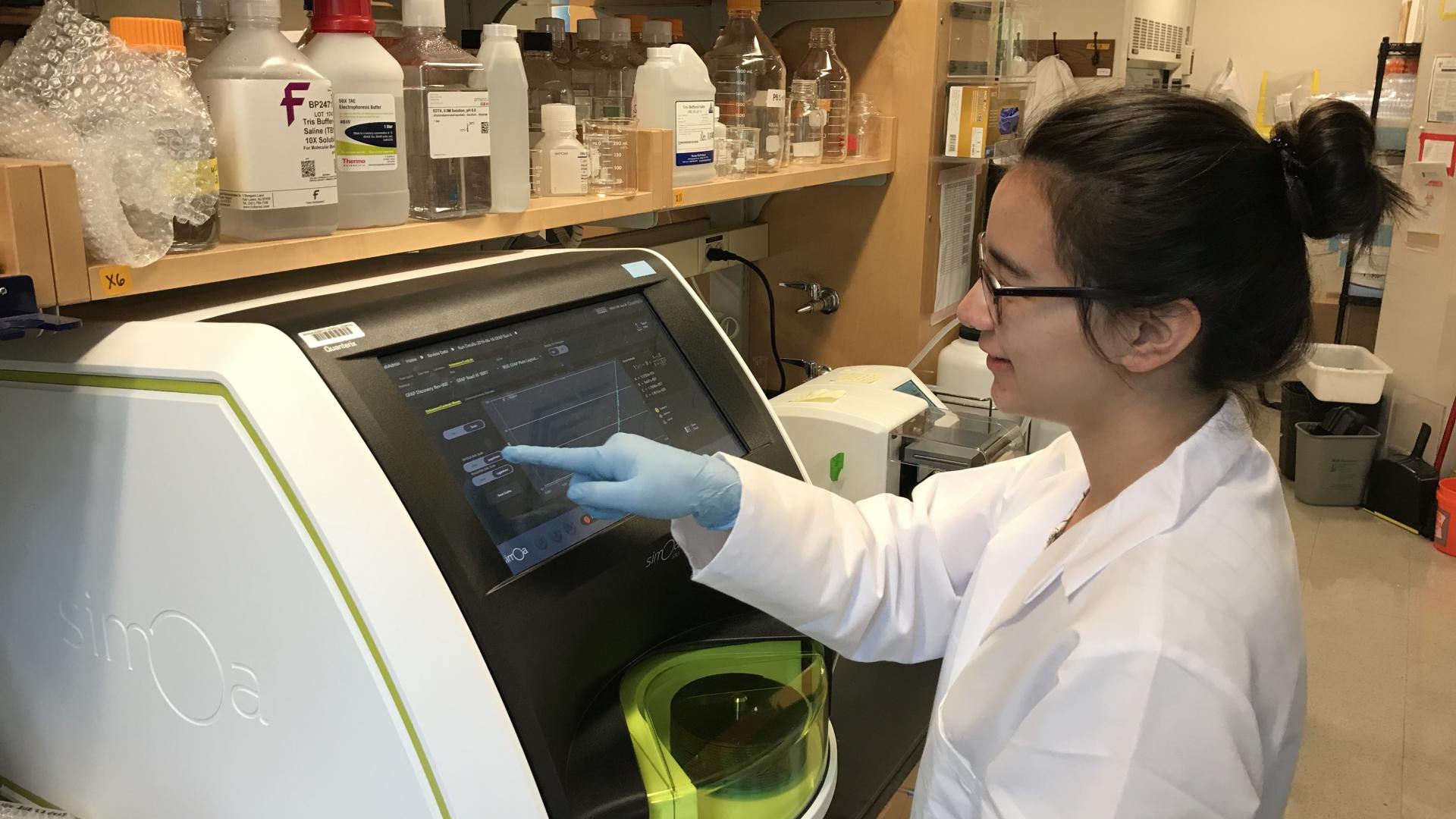 Research Technologist Bianca Trombetta, BS, operates the Quanterix SR-X equipment, an ultra-sensitive automated biomarker detection system used to identify proteins in the tissue samples.