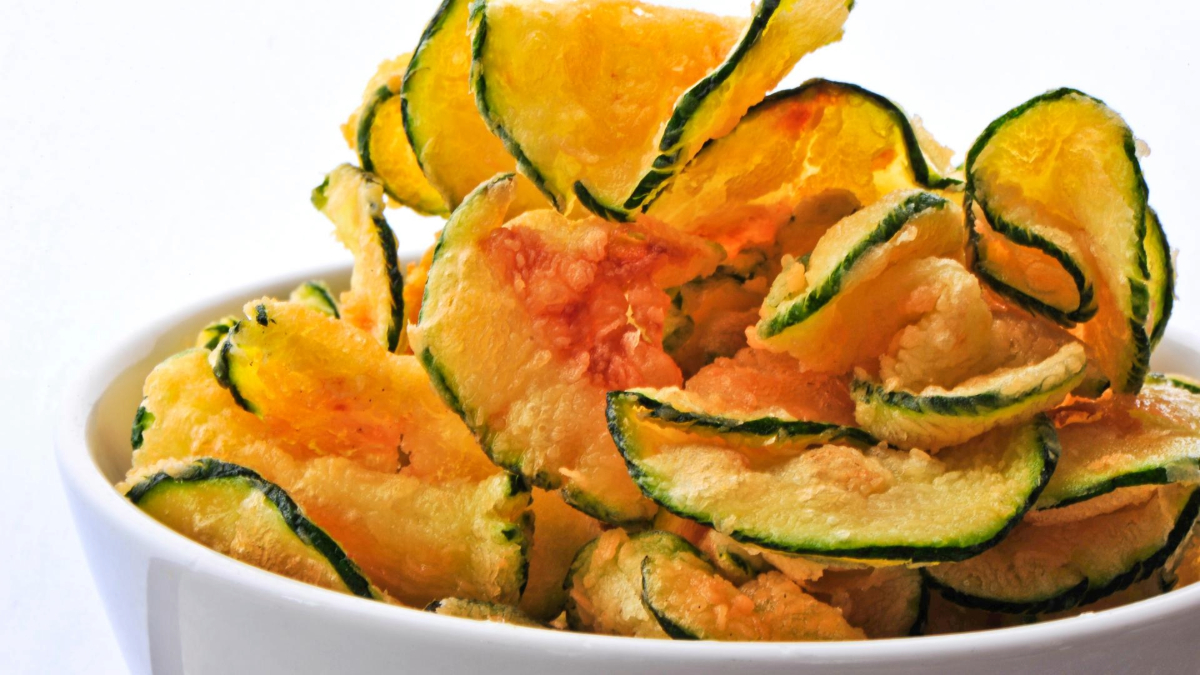 A bowl of crispy zucchini chips with a golden-brown texture.