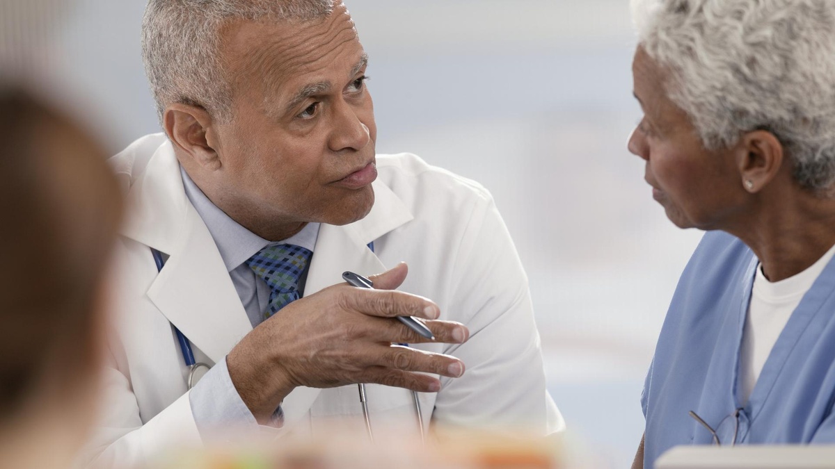 A doctor speaks to an older male patient.