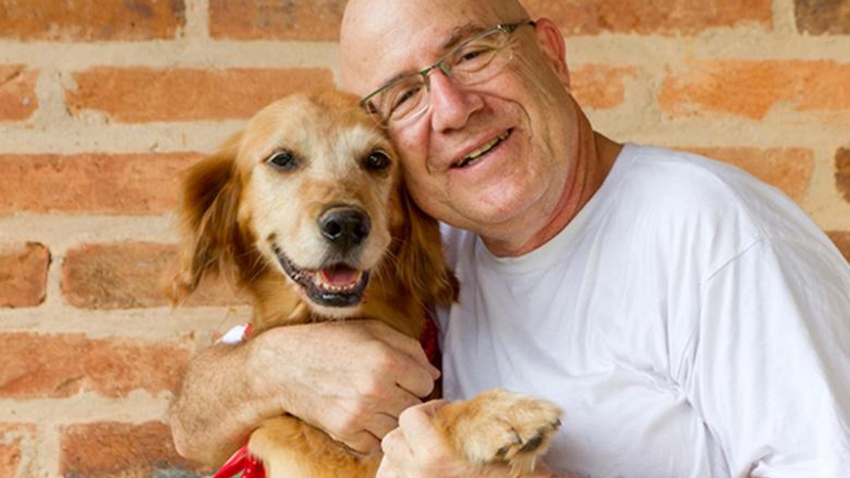 Senior man with a medium-sized yellow dog.