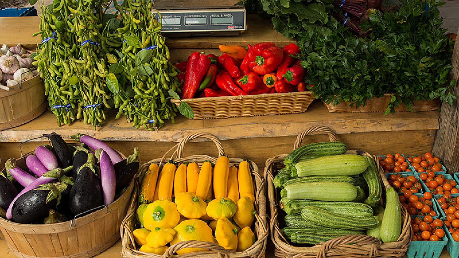 Colorful fruits and vegetables displayed at an outdoor market.