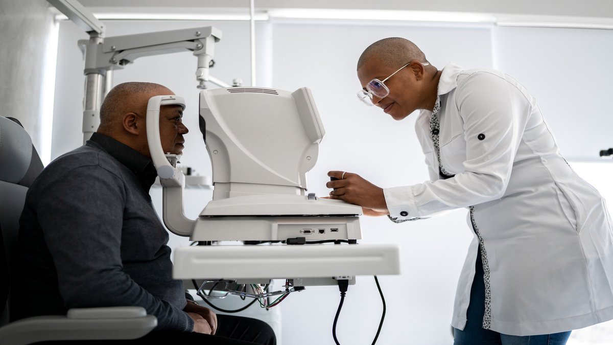 A doctor performing an eye exam on a patient using advanced optical equipment in a clinical setting.