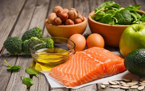 Fish, eggs, and healthy vegetables on a wooden table.