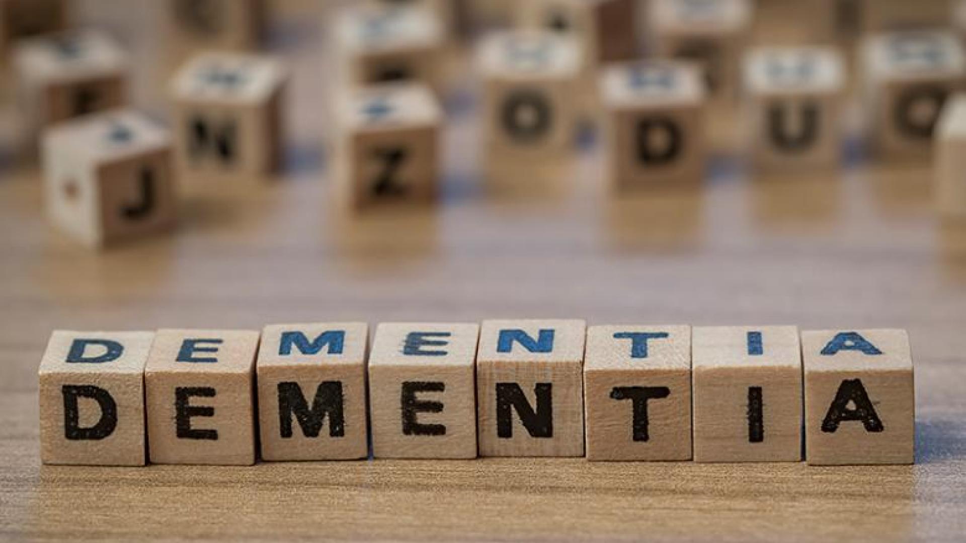 wooden letter blocks spelling out DEMENTIA with several other random, out-of-focus letter blocks in the background