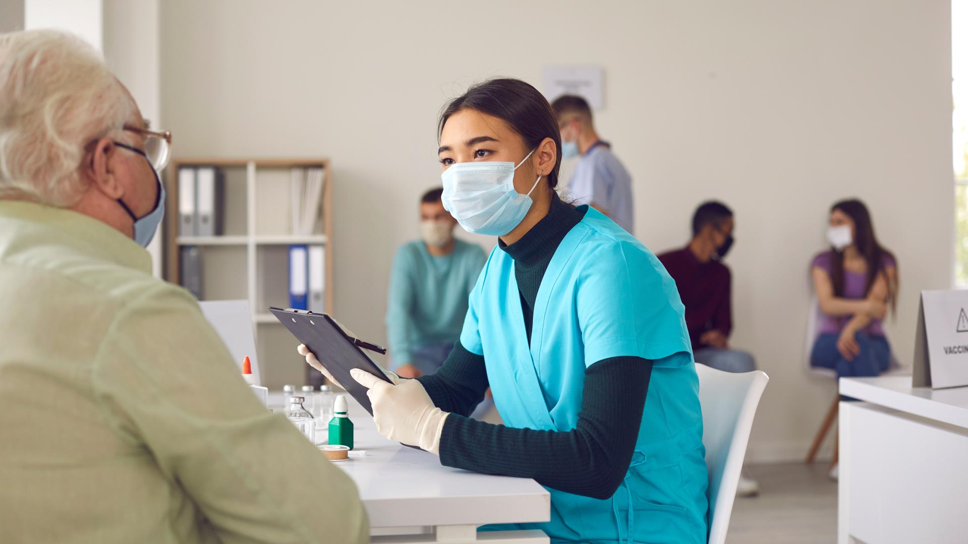 A nurse informs an older man.