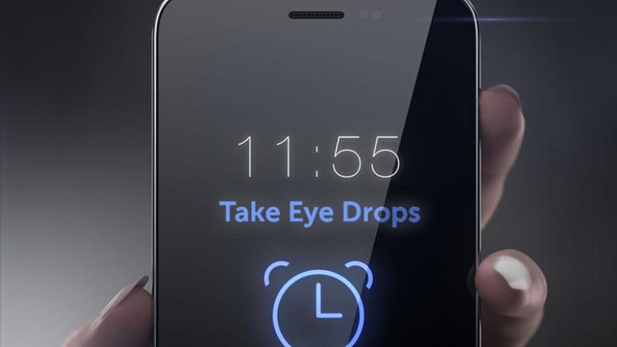 A smartphone displaying a reminder at 11:55 to 'Take Eye Drops,' with an alarm clock icon underneath