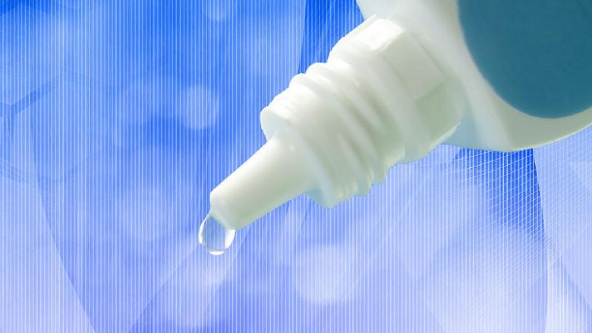 a close-up photo of the end of a dropper bottle with a drop of liquid coming out of the tip