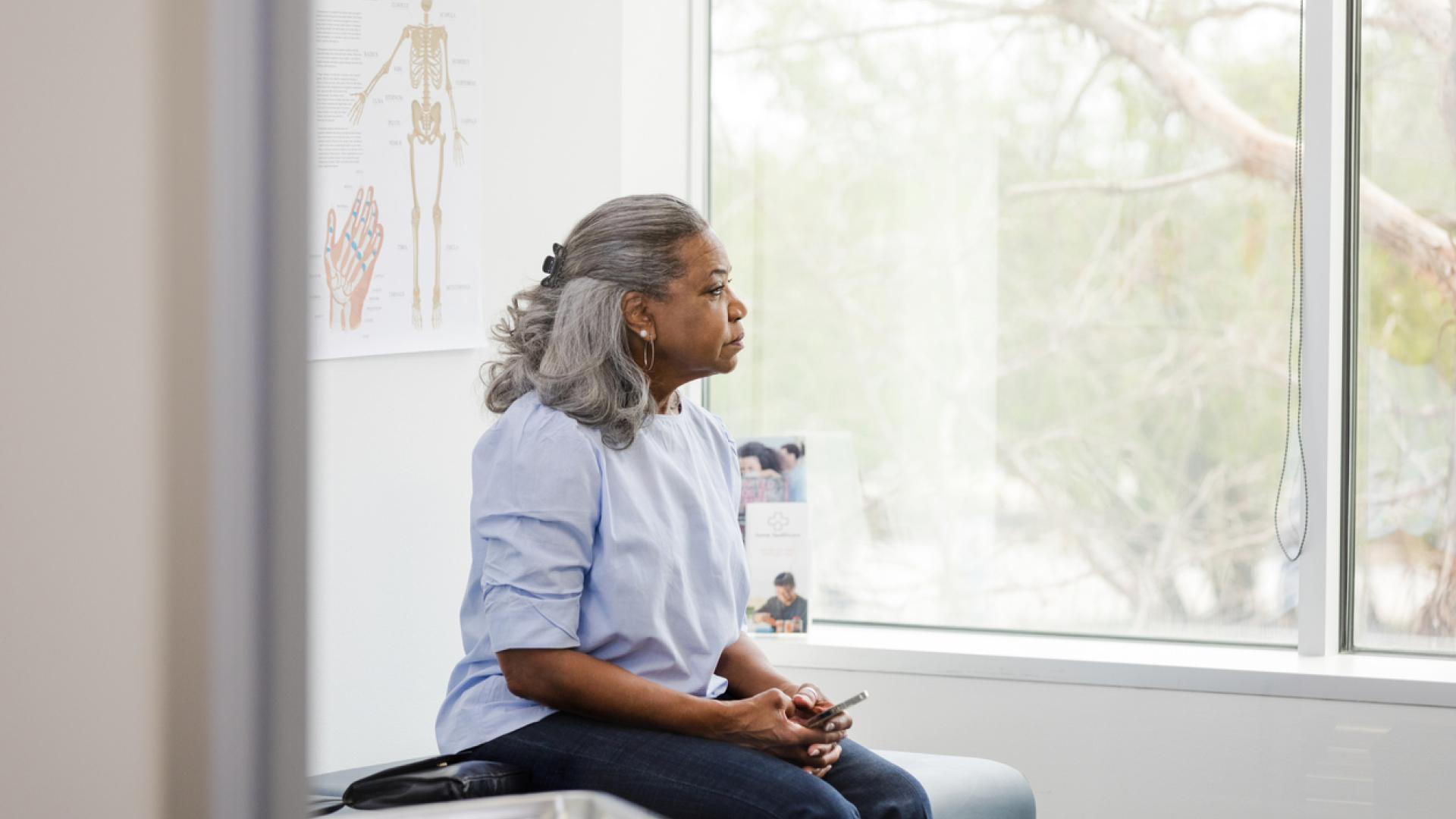 Woman looking out window of doctor's office.