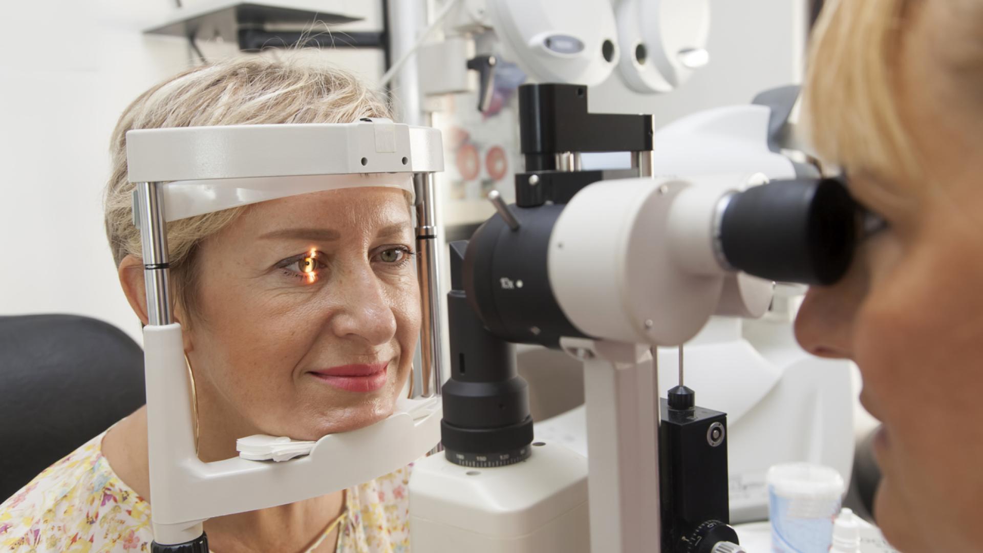 a woman in the process of taking the visual field test part of her eye exam