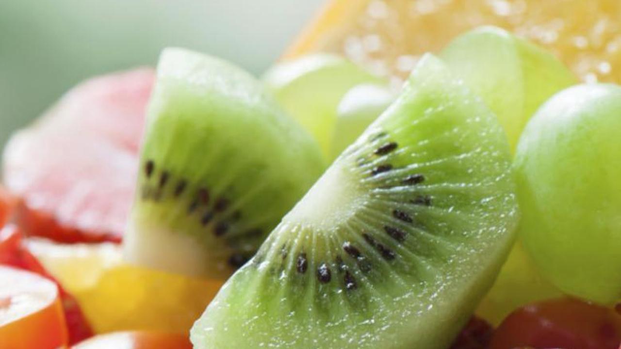 Close-up of fresh fruits, including kiwi and grapes, promoting a healthy diet.