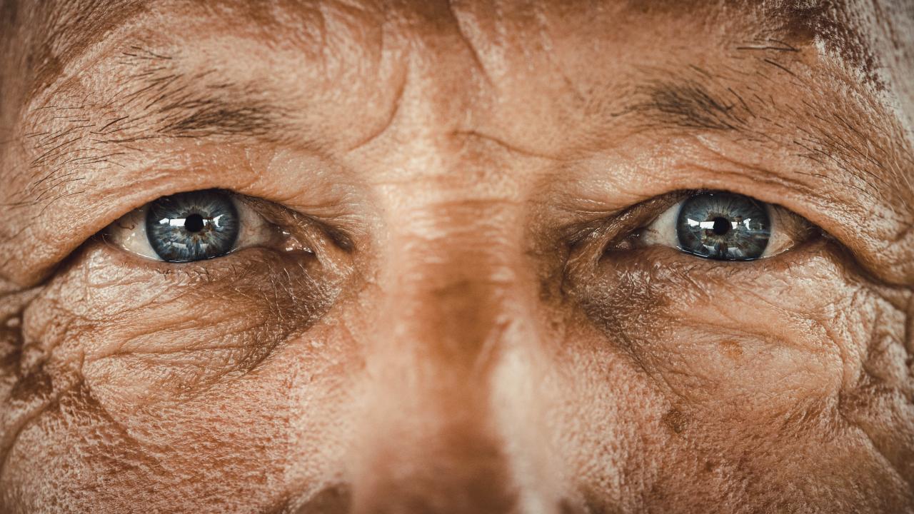 Close-up of an elderly man's eyes, highlighting risk factors for eye conditions.