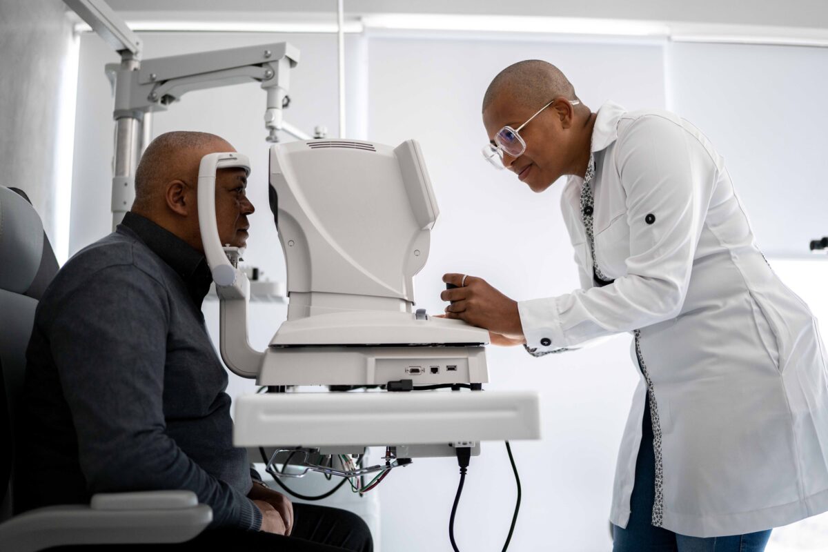 Healthcare provider conducting an eye exam on a patient using specialized equipment in a clinical setting.