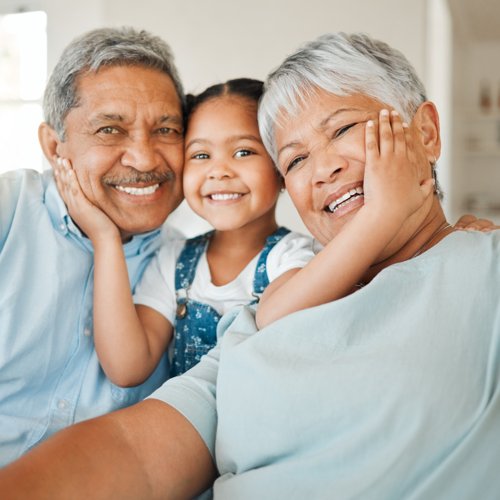 Shot of grandparents bonding with their granddaughter on a sofa at home.