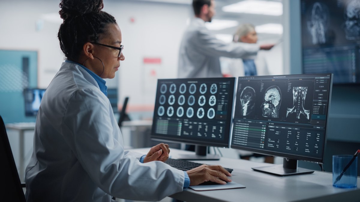 A female researcher looking at brain scans on a computer.