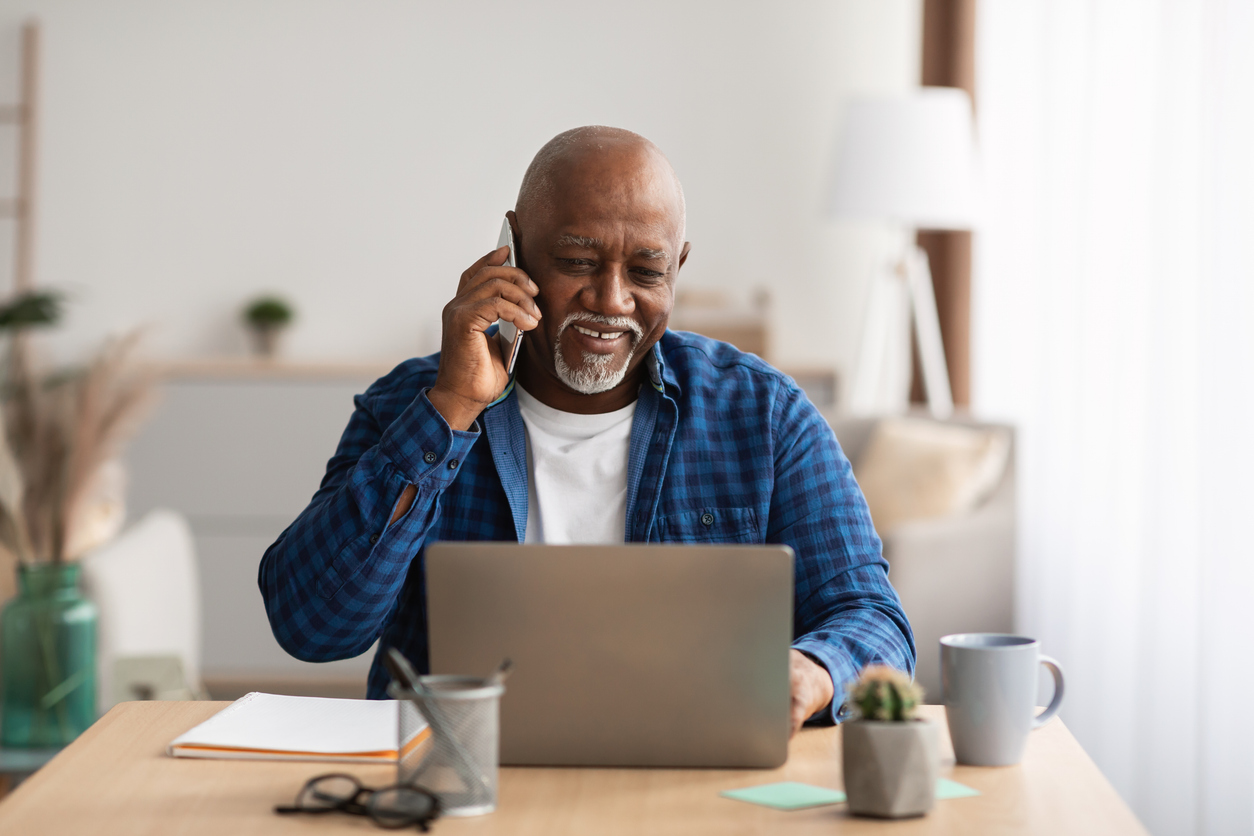 Man on phone in front of laptop