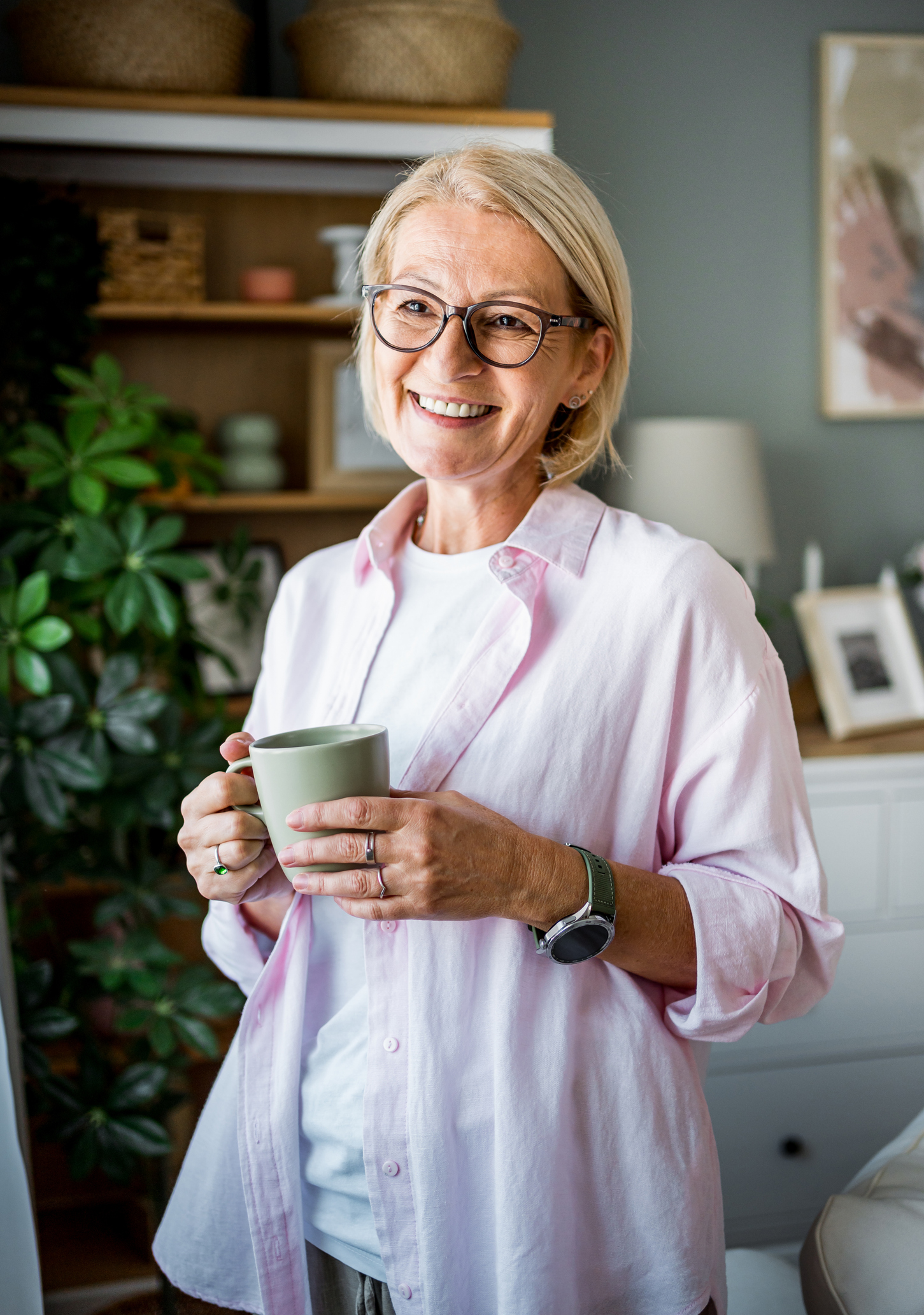 Portrait of a cheerful mature woman drinking coffee while relaxing at home