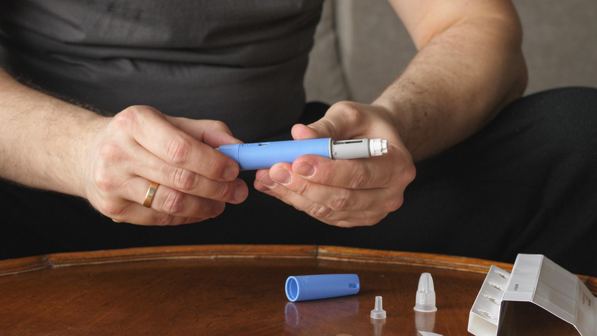 A man looks at his injectable medication.