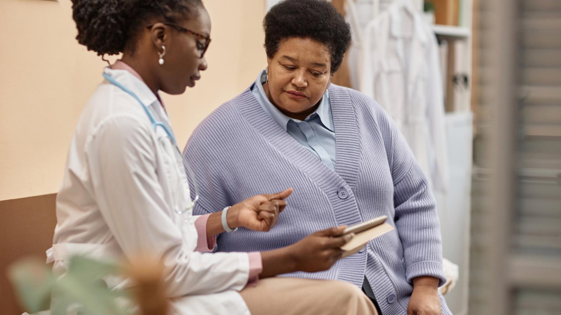 An elderly woman speakers with her physician.